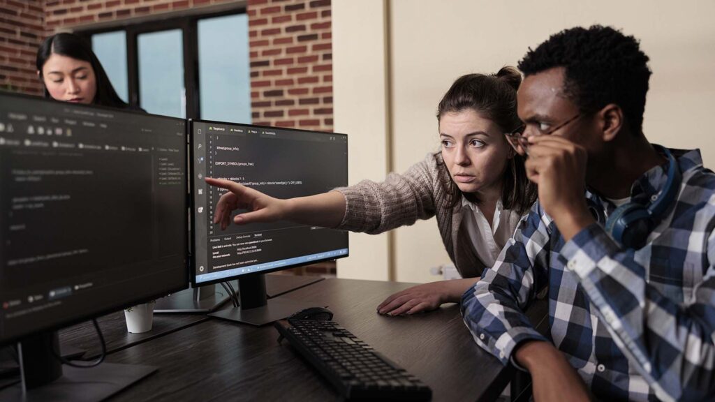 Man and woman looking and pointing at a computer screen