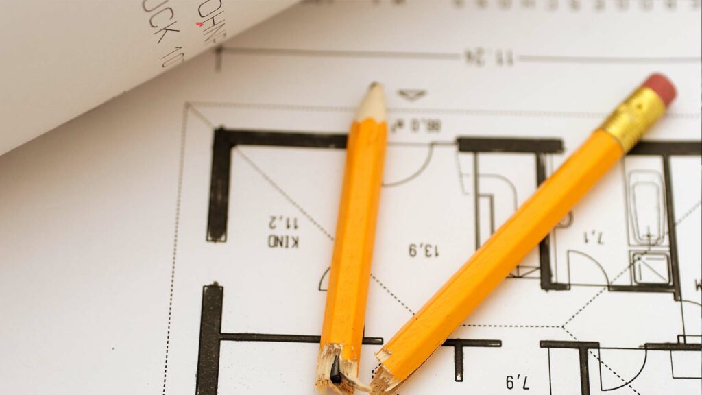 Close up of architecture plans with broken pencil laying on top.